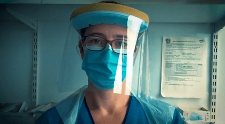 Nurse with face mask and visor looking directly at the camera