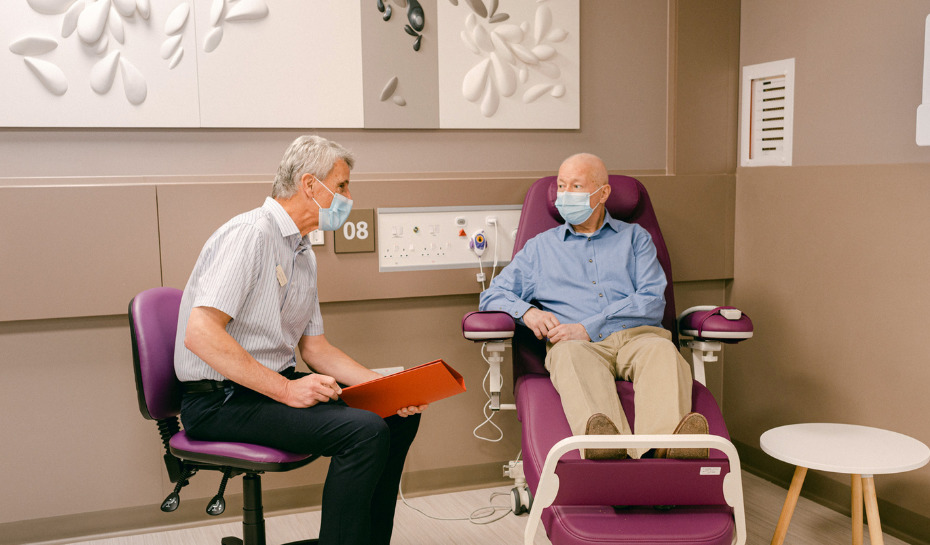 Patient sat in a chair looking at a doctor