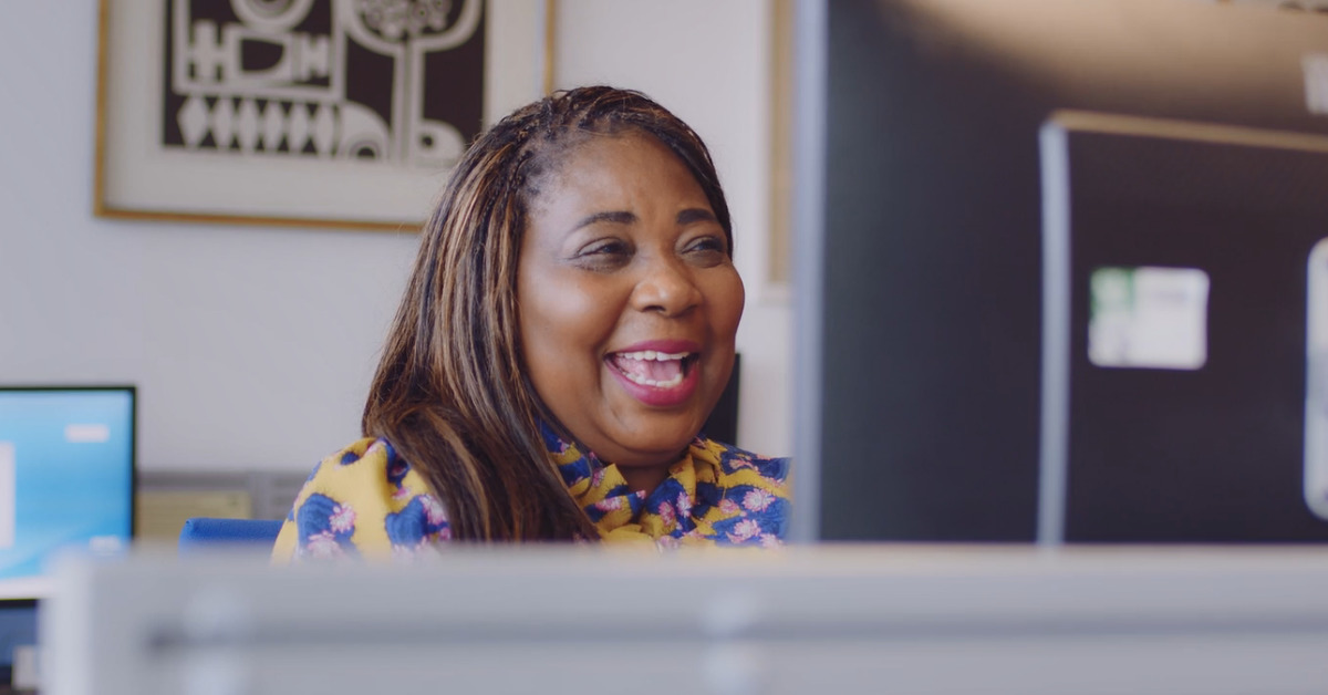 Women smiling looking at a computer in an office