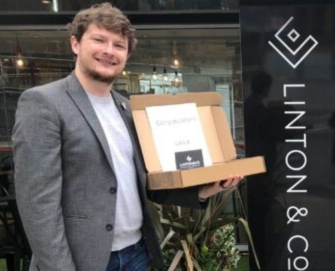 Man holding box of brownies in front of shop