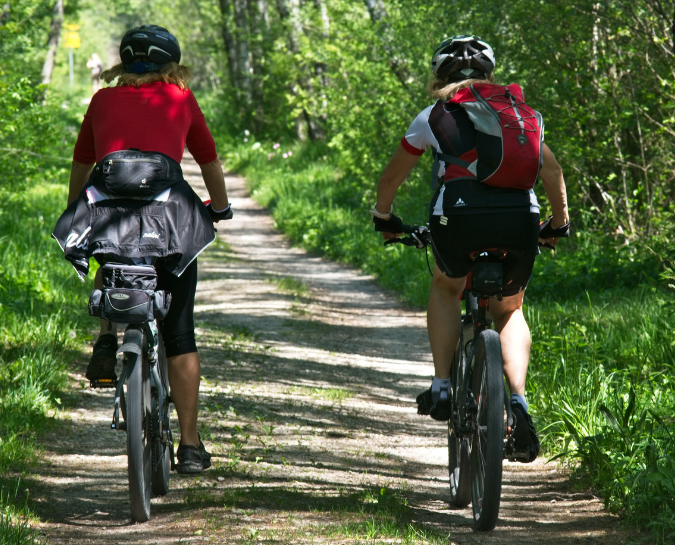 Two cyclists riding their bikes along a path