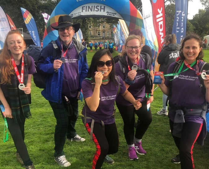 Kiltwalk participants at the finish line showing off their medals