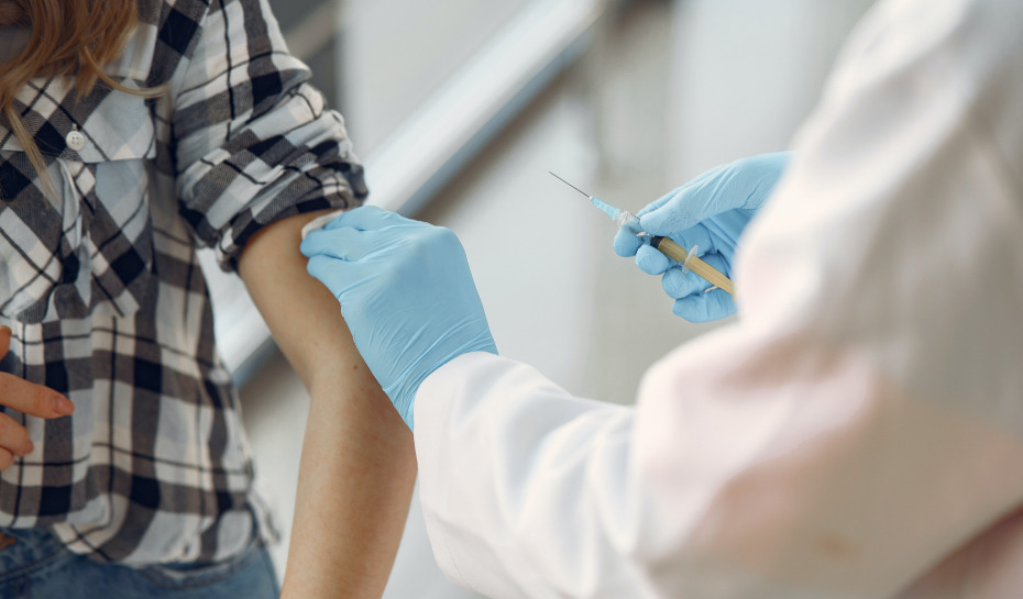 Vaccinator holding syringe to put in patient's arm