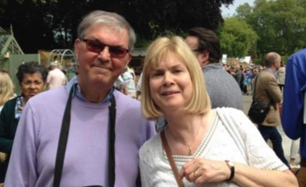 Alan stood smiling at the camera next to his wife Flora