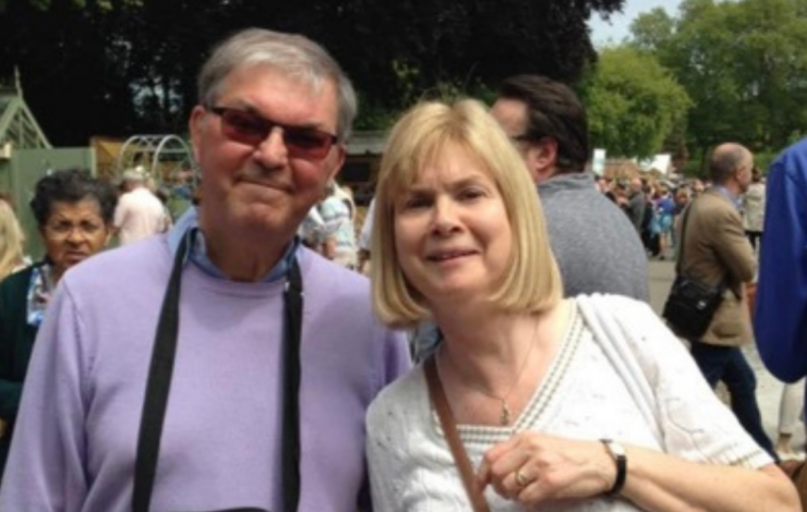 Alan stood smiling at the camera next to his wife Flora