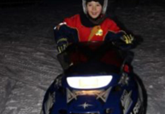 Michaelaghs son on snow mobile smiling