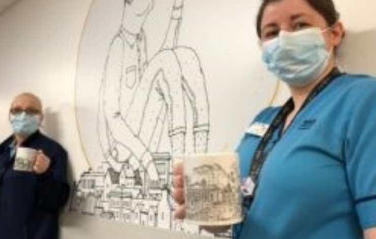 Nurses holding mugs in front of an image
