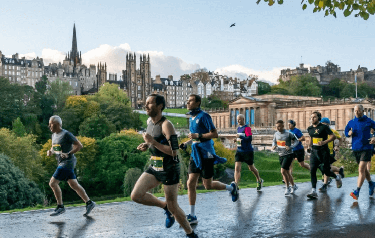 Men running along a path with Edinburgh Skyline in the background