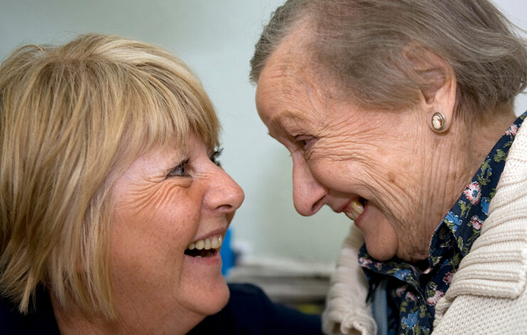 Nurse and elderly patient smiling at each other