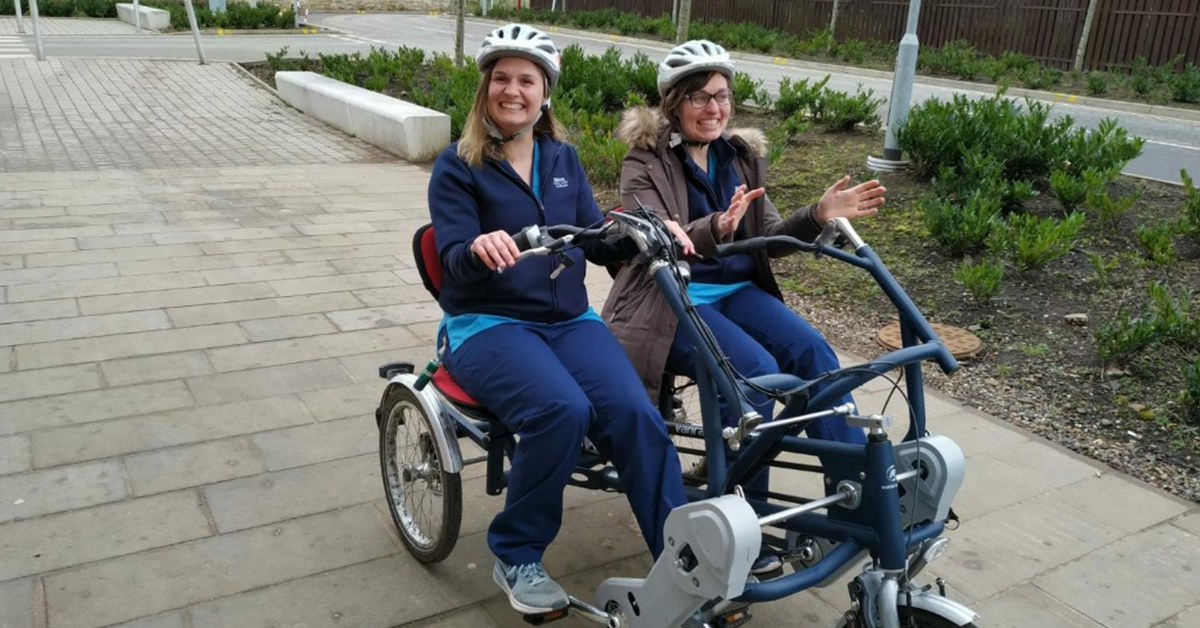 Lothians charity staff riding double bike while smiling