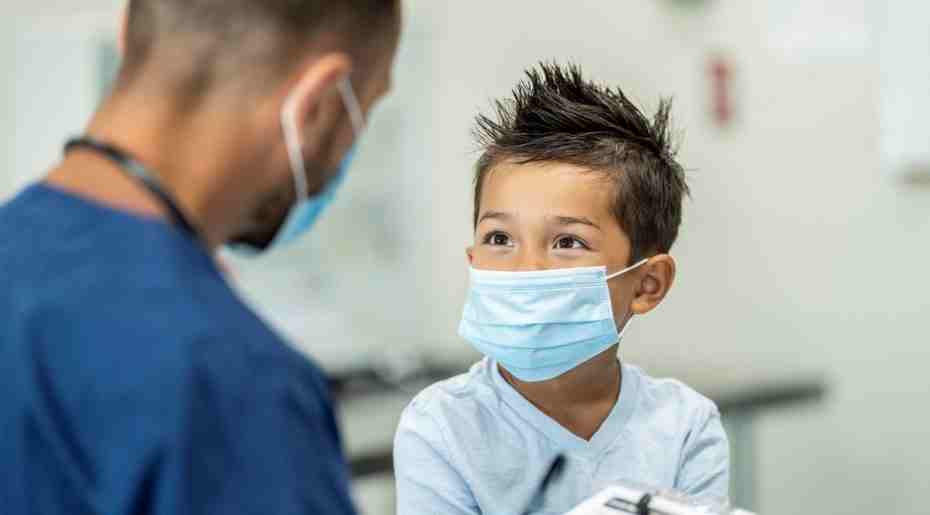 Child patient with mask talking to a nurse