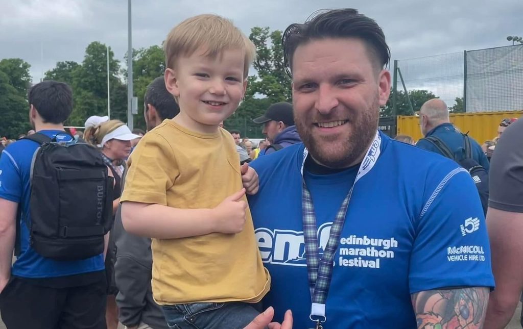 Fundraiser, Aaron Tilley, with his son after completing the Edinburgh Marathon Festival for NHS Lothian Charity.