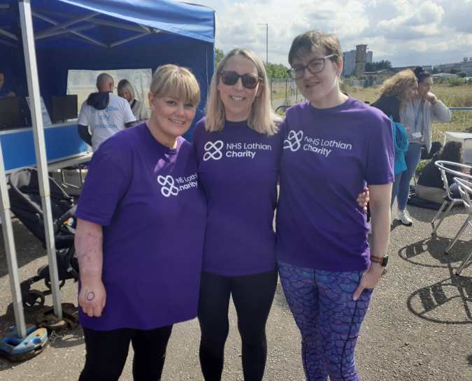 Three NHS Lothian Charity Champions smiling at the camera. All wearing a purple NHS Lothian Charity purple t-shirt.