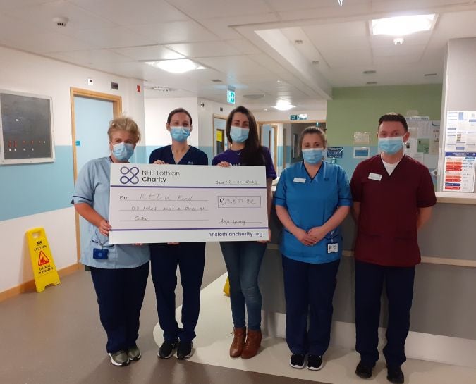 Amy Young presenting a cheque to the REDU team at St John's Hospital