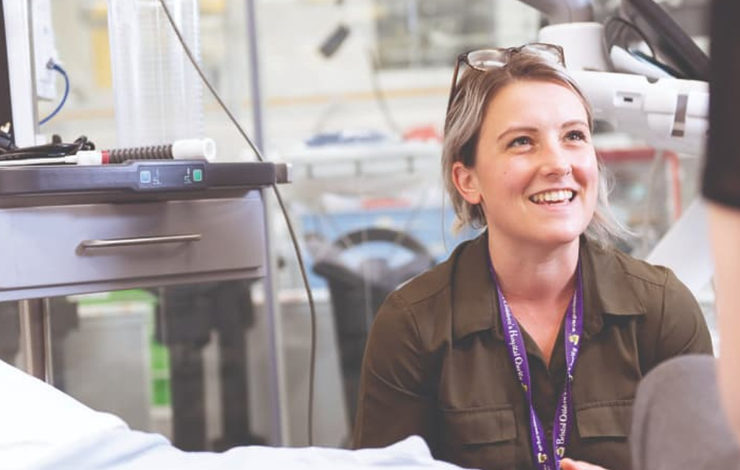 NHS member of staff in a hospital smiling at a patient