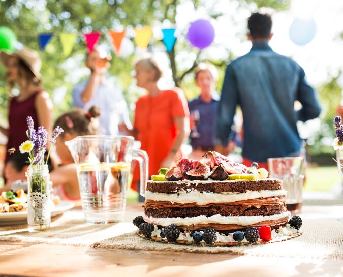 Cake on a table with balloons in the background