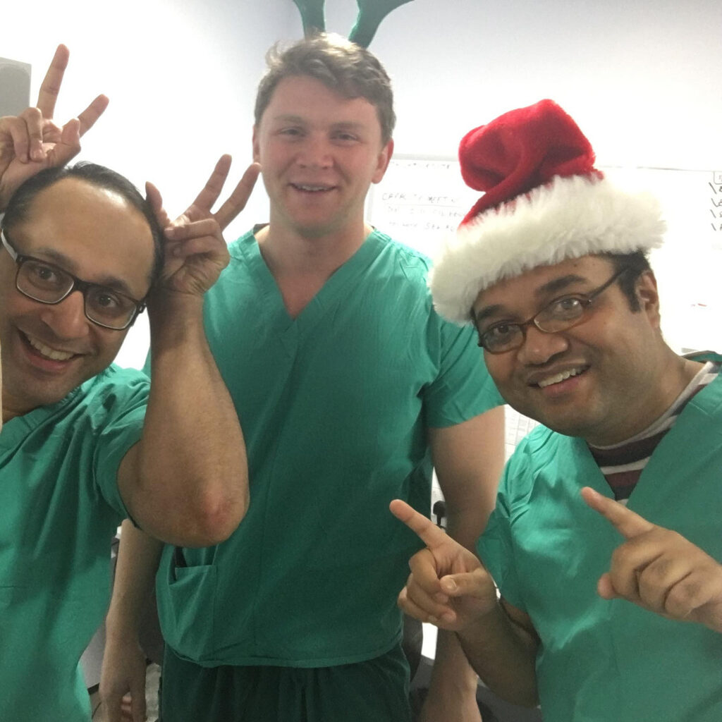 3 members of NHS Lothian staff from the Labour Ward at St Johns smiling at the camera wearing Santa hats and reindeer antlers. 