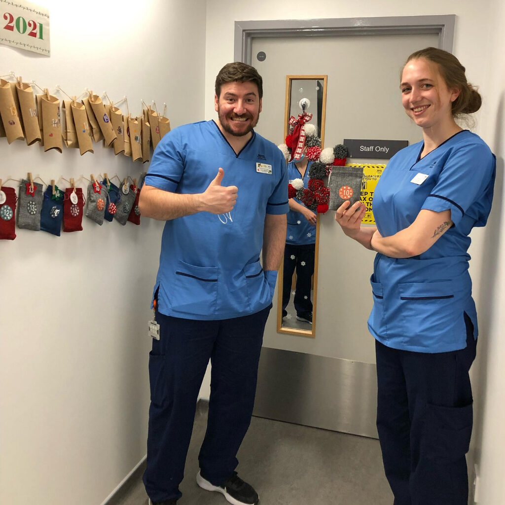 2 members of NHS Lothian Staff stood by a decorated wall on Christmas day on the RHCYP PCCU ward