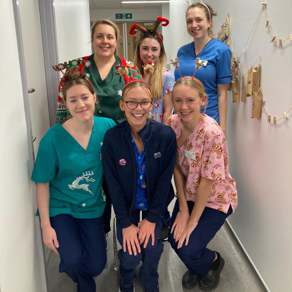 6 NHS Lothian staff on the RHCYP PCCU ward dressed up in festive outfits smiling at the camera
