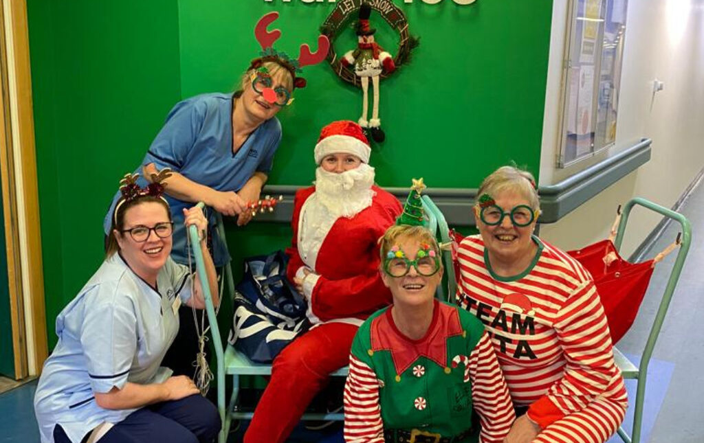 5 members of NHS staff sat outside the Vascular Surgery ward at the Royal Infirmary of Edinburgh dressed up as elves and Santa.