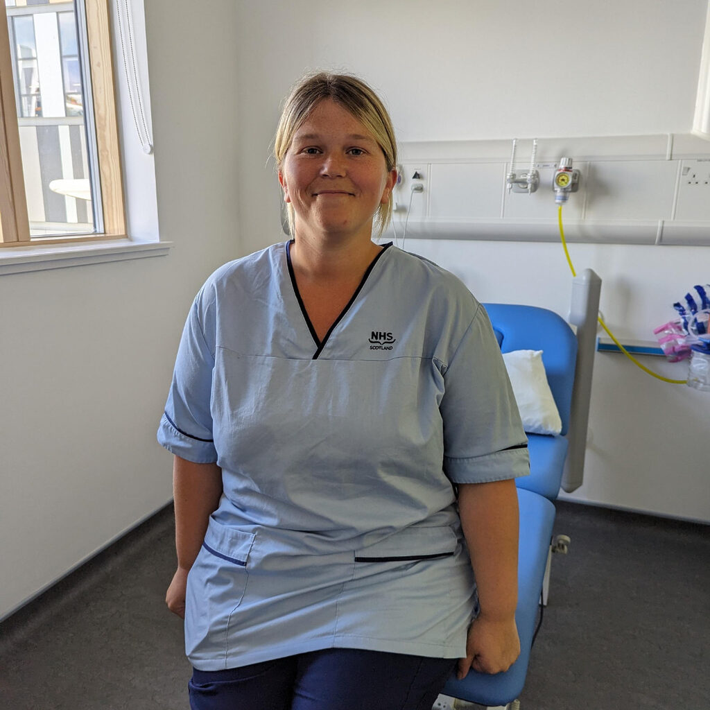 Rachael from the Research Department at RHCYP sat on a bed smiling 