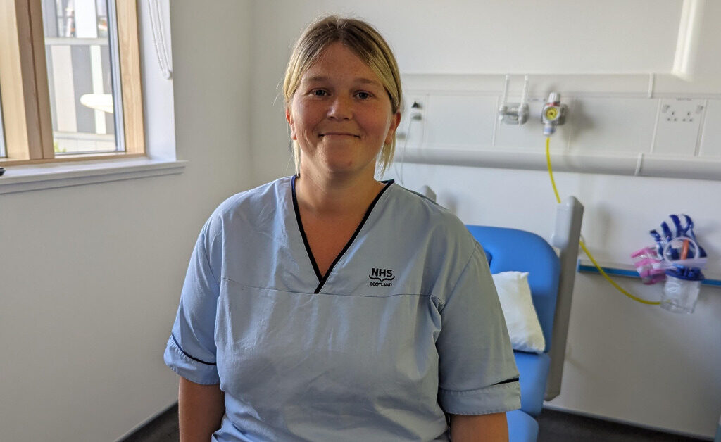 Rachael from the Research Department at RHCYP sat on a bed smiling