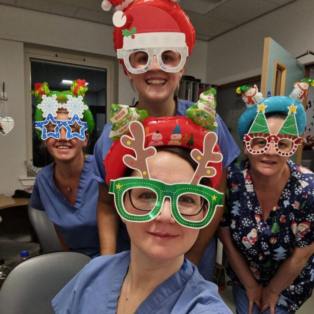 Four member's of NHS Lothian staff from the Special Care Baby Unit at St Johns wearing santa hats and festive glasses