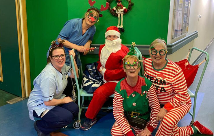 5 members of NHS staff sat outside the Vascular Surgery ward at the Royal Infirmary of Edinburgh dressed up as elves and Santa.