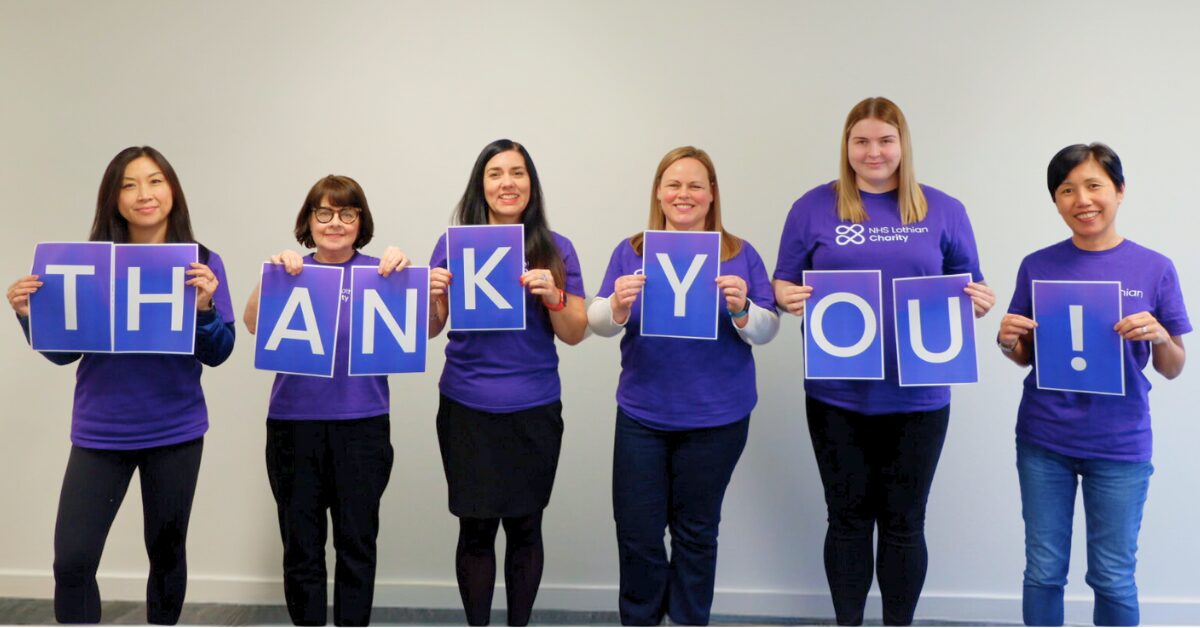 NHS Lothian Charity staff wearing purple t-shirts holding up letters that spell 'Thank You!'