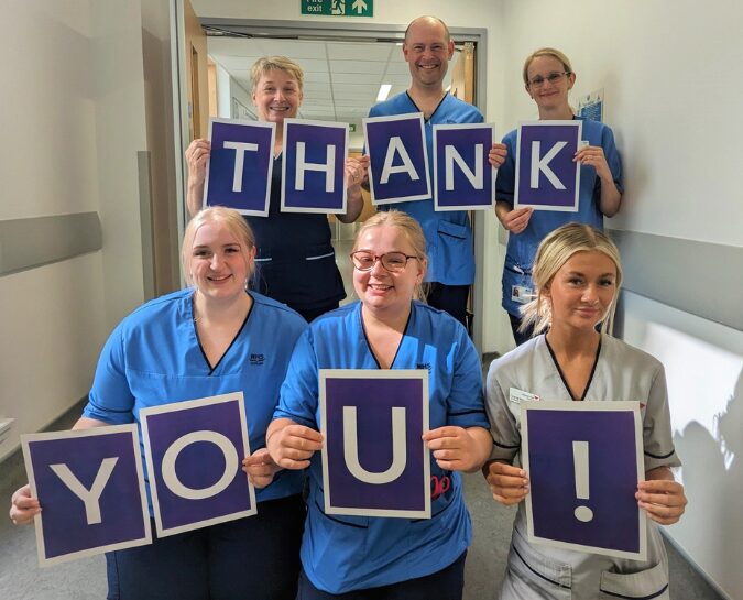 NHS Lothian staff holding up signs that spell out 'Thank You!'