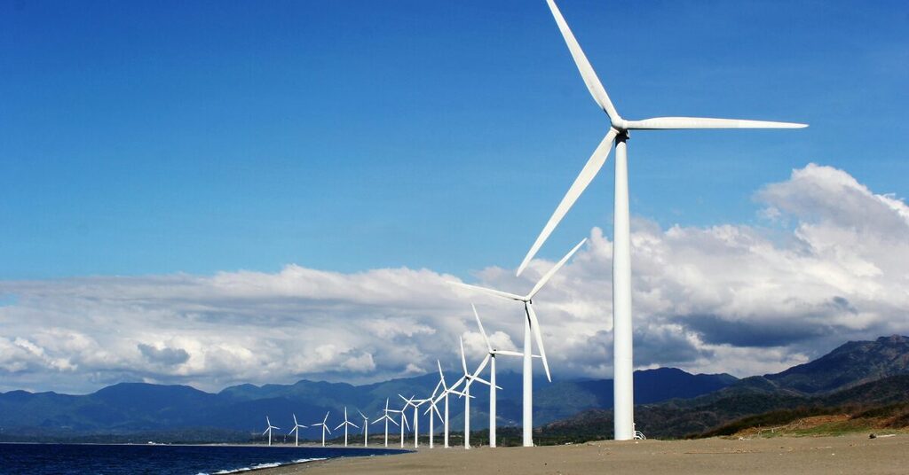 Clean energy wind turbines beside a shore