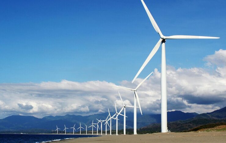 Clean energy wind turbines beside a shore
