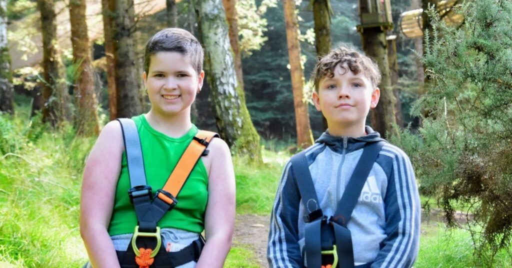 two children with harnesses facing the camera