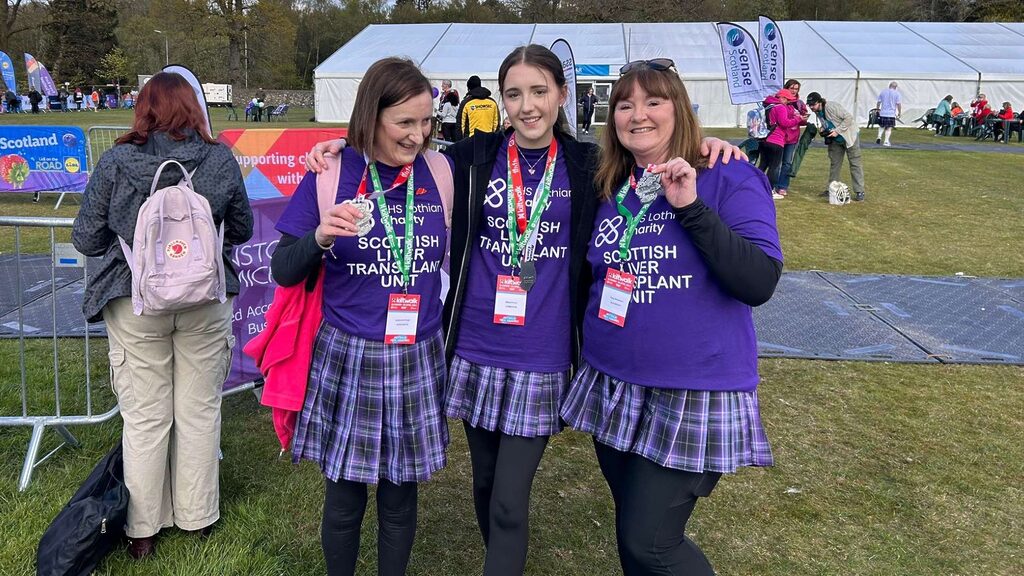 Katherine, her daughter Olivia and friend Tracy holding their medals at the finish line of the Kiltwalk