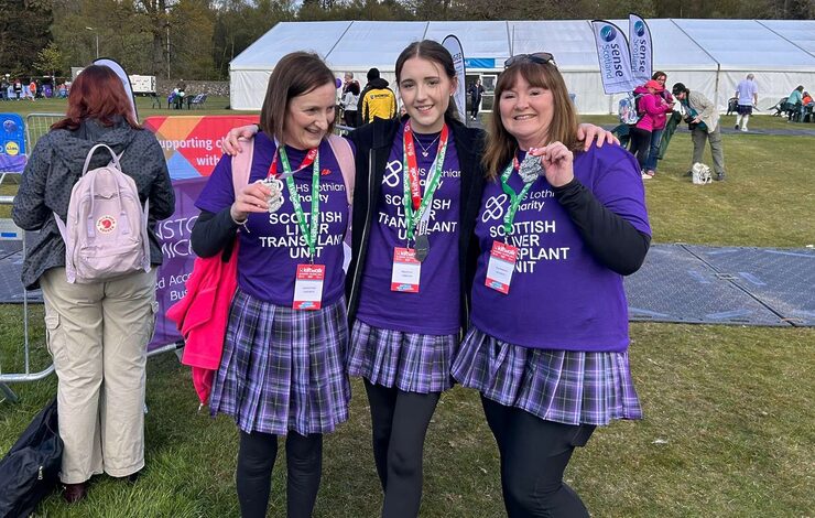 Katherine, her daughter Olivia and friend Tracy holding their medals at the finish line of the Kiltwalk