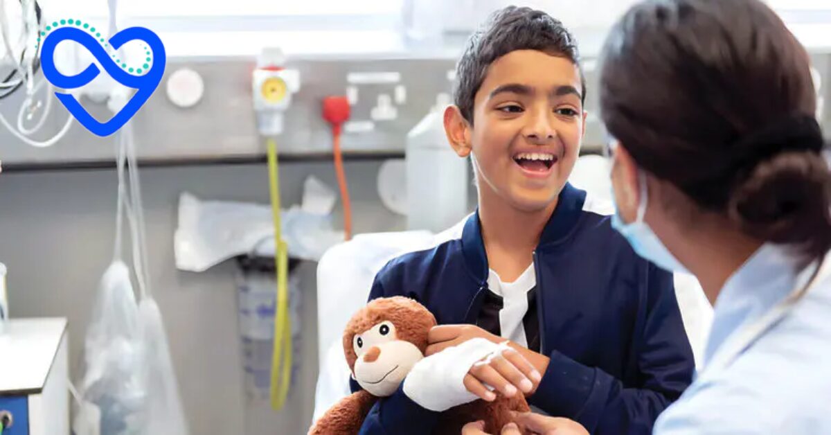 Boy smiling at the camera with a bandage on his arm cuddling a monkey.