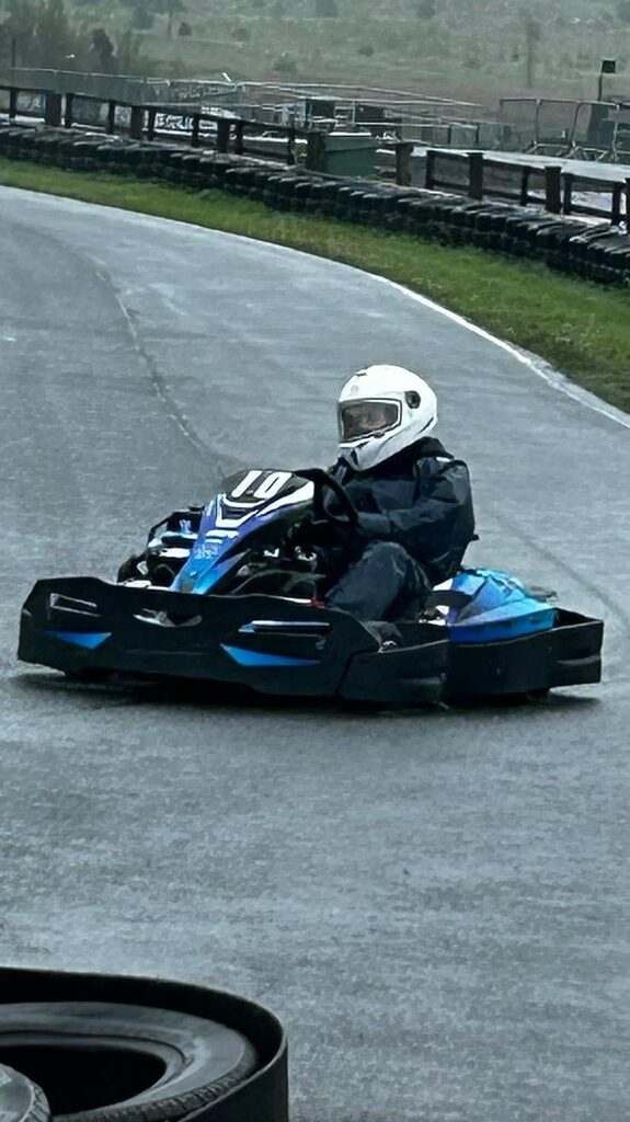 Patient wearing a helmet in a care driving around a track.