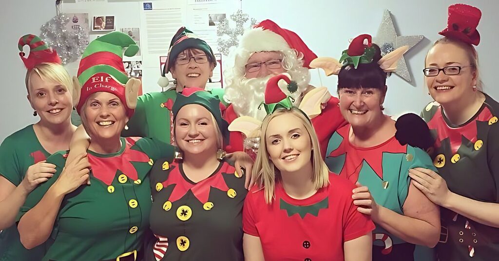 Eight members of NHS staff smiling at the camera wearing elf costumes