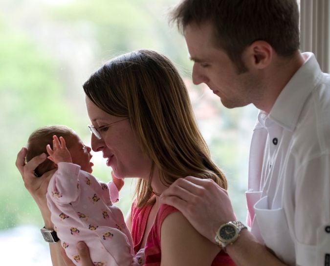 man and woman holding a baby