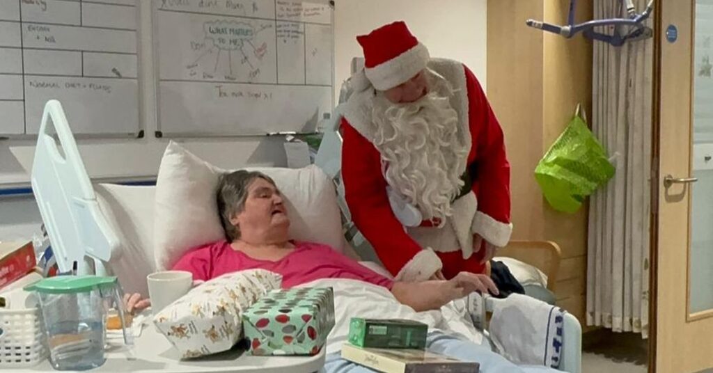 A patient getting presents from Santa while spending Christmas in hospital