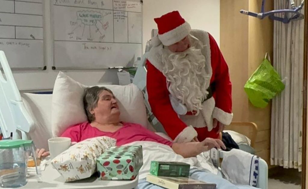 Mary, a patient in East Lothian Community Hospital getting presents from Santa while spending Christmas in hospital