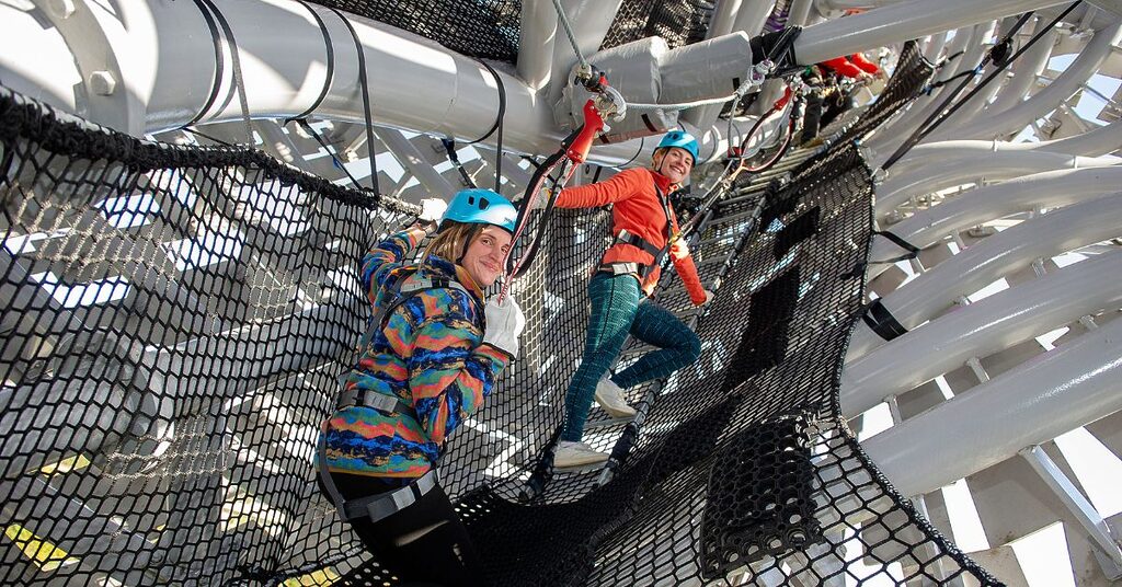 two women climbing through the inside of the Kelpies as part of the Kelpies Experience