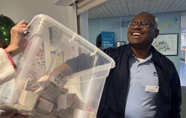 a member of staff pulling a ticket out of a bucket