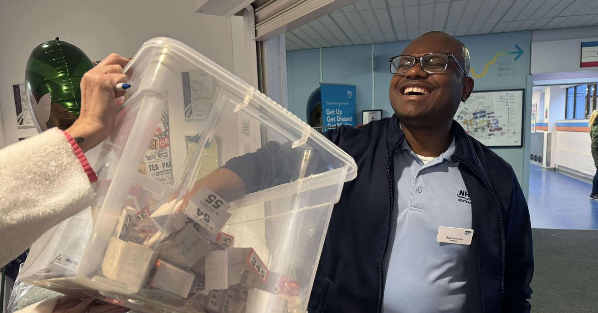 a member of staff pulling a ticket out of a bucket