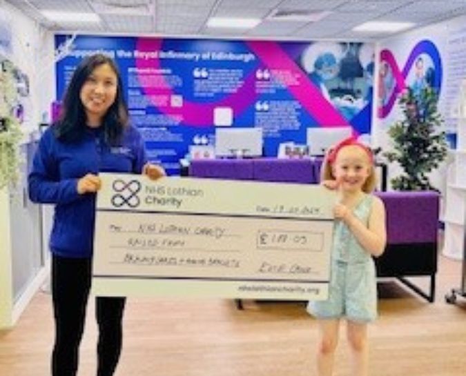 Evie Crole presenting a cheque to staff for the money she raised