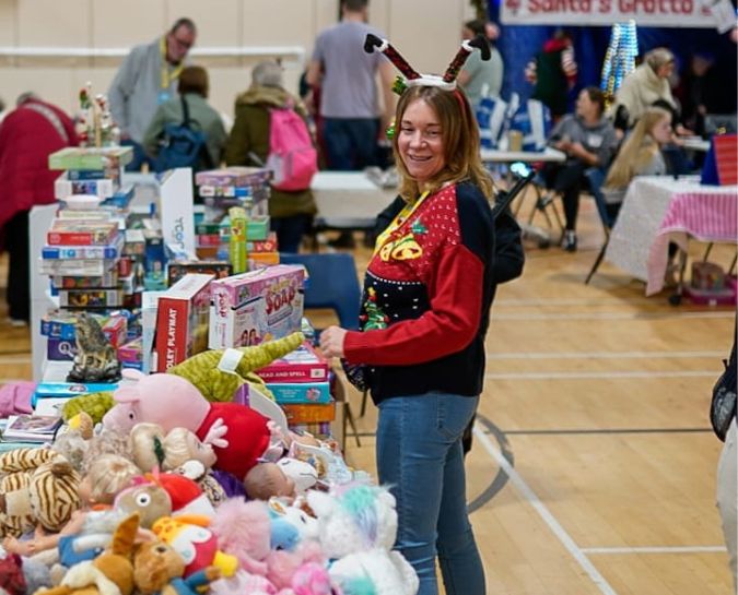 A FACE volunteer staffing a stand at their winter fair