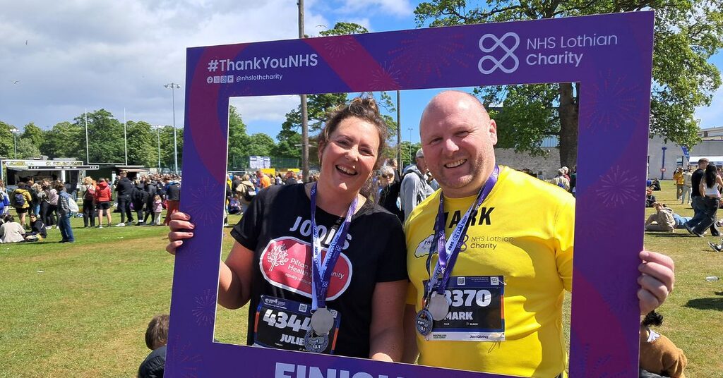 two volunteers from our FACE fund holding a finisher frame at the end of EMF 2025