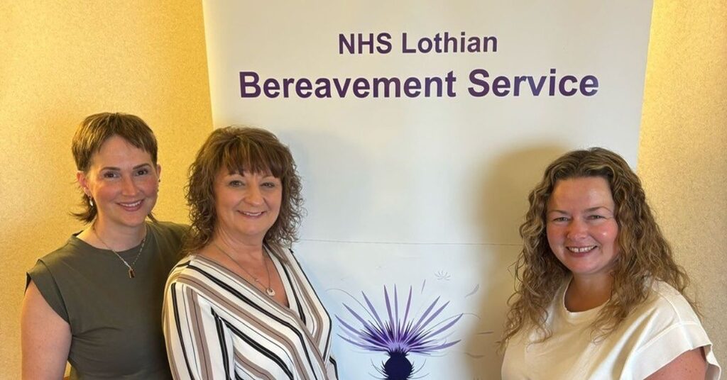 three staff from bereavement services standing in front of a banner
