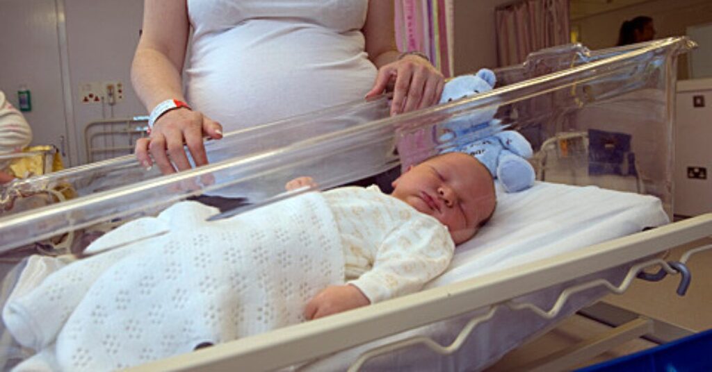 new born baby with mother looking in