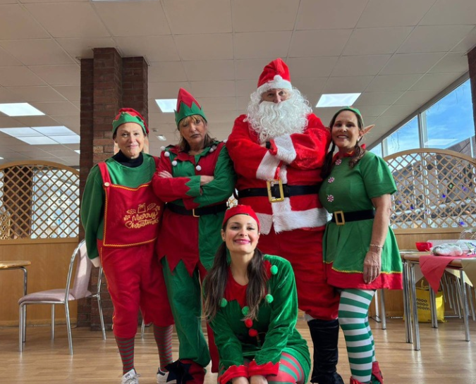 Group of people dressed up as Elves and Santa.